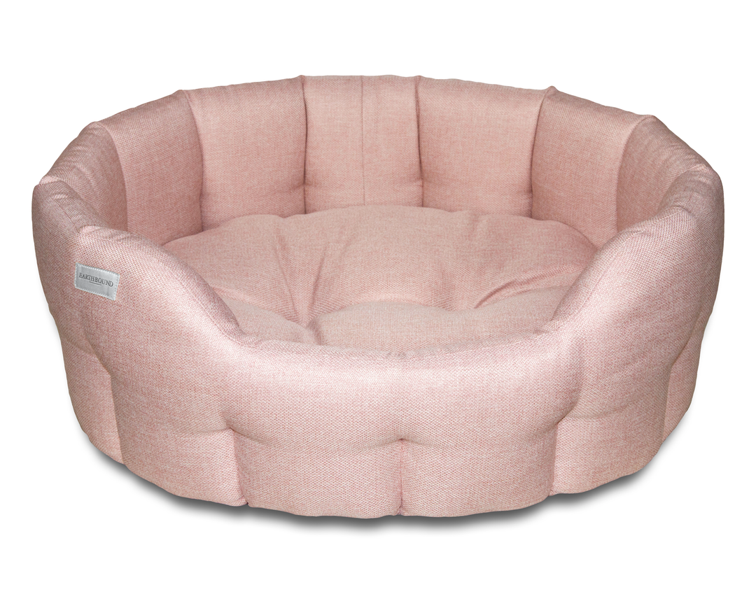 A round pink dog bed with a plush texture and a waterproof base, designed for comfort and durability.