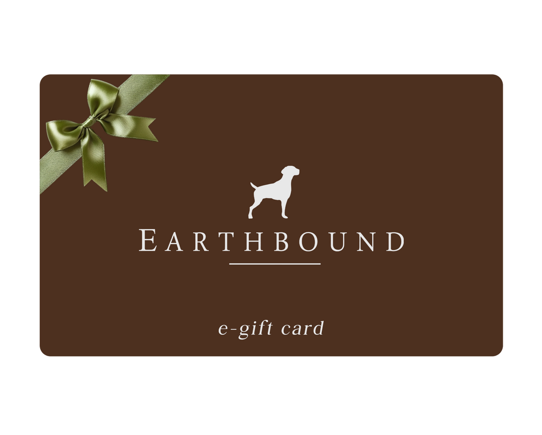 An Earthbound e-gift card with a dark brown background, featuring a white dog silhouette logo, the brand name 'EARTHBOUND' in white, and a green ribbon graphic in the top-left corner.